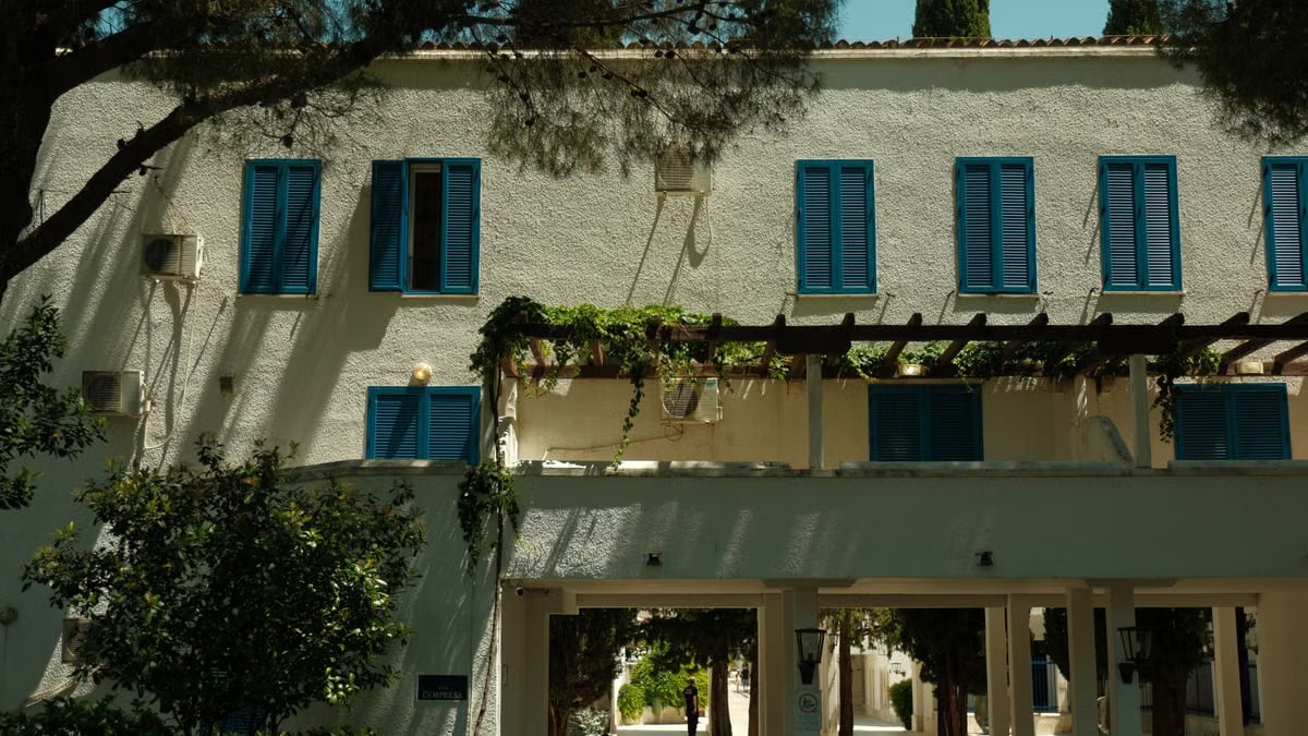 Sunny building facade with distinct blue shutters in Budva, Montenegro.